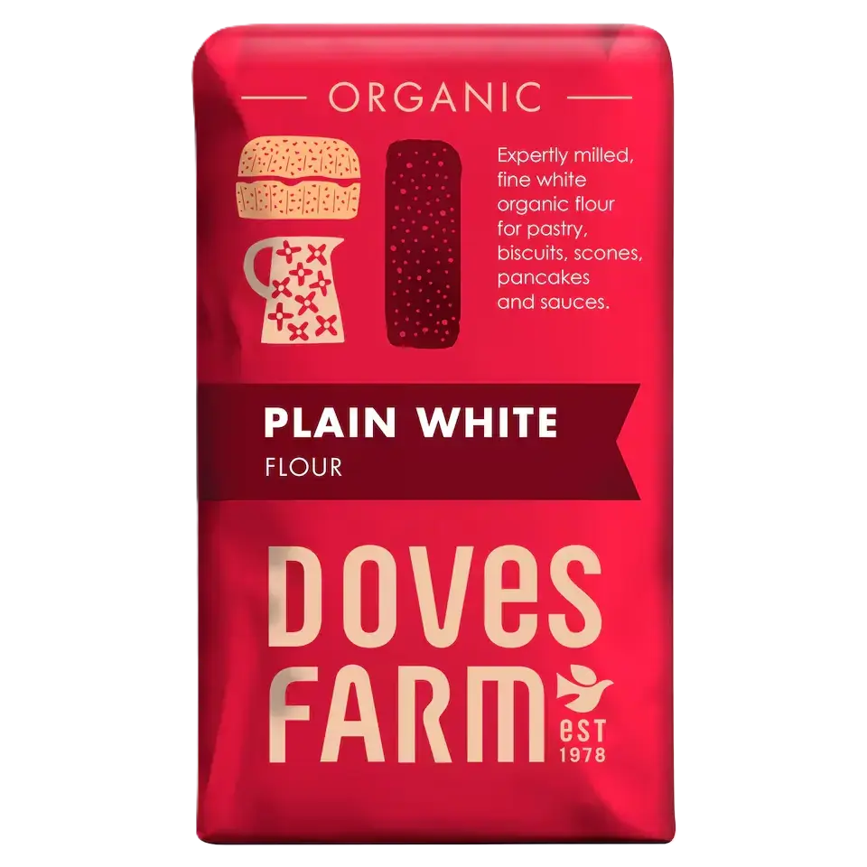 A red bag of Doves Farm Organic Plain White Flour, featuring illustrations of a burger and a pitcher, with the brand name 'Doves Farm' in large cream letters at the bottom.