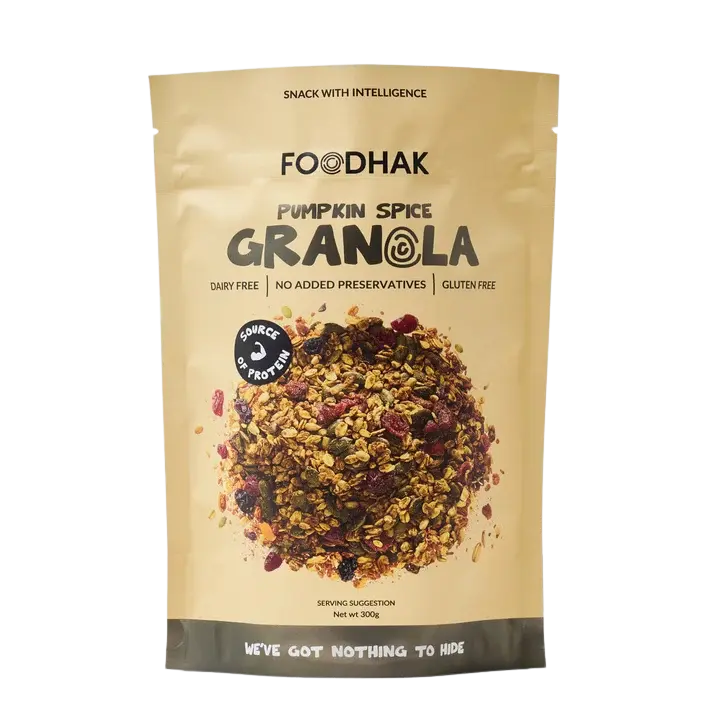 A stand-up pouch of Foodhak Pumpkin Spice Granola on a plain white background. The packaging is a warm beige/tan color with black text and a photo of the granola mix in the center.