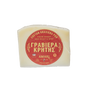A wedge of Cretan Graviera PDO cheese wrapped in clear plastic, featuring a prominent red circular label with gold Greek text and the brand name AMARJ, on a plain white background.