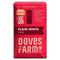 A red bag of Doves Farm Organic Plain White Flour, featuring illustrations of a burger and a pitcher, with the brand name 'Doves Farm' in large cream letters at the bottom.